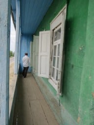Николай Васильевич открывает ставни дома, в котором проходит собрание